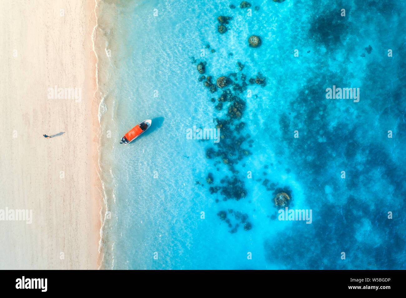 Aerial view of the fishing boat in clear blue water at sunny day in ...