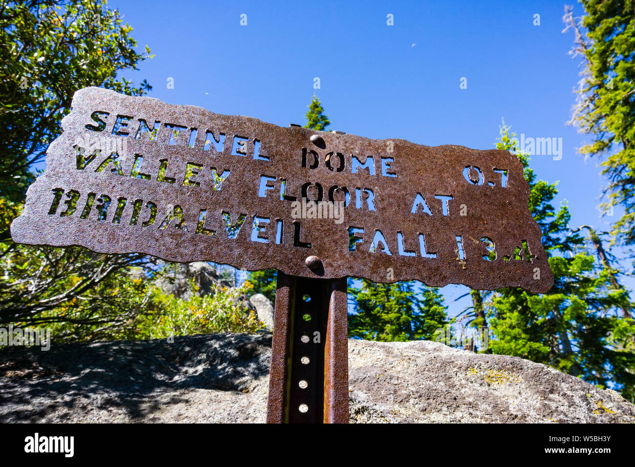 Hiking trail sign posted on the trail to Sentinel Dome, close to Glacier Point, showing points of interest and distances; Yosemite National Park, Sier Stock Photo