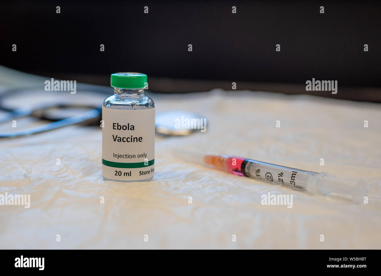 Illustrative Ebola vaccine vial with stethoscope and syringe Stock Photo