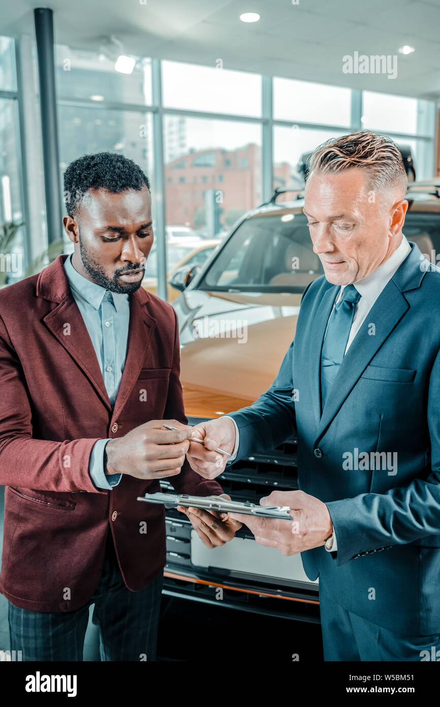 Man concluding a contract bying new car. Stock Photo