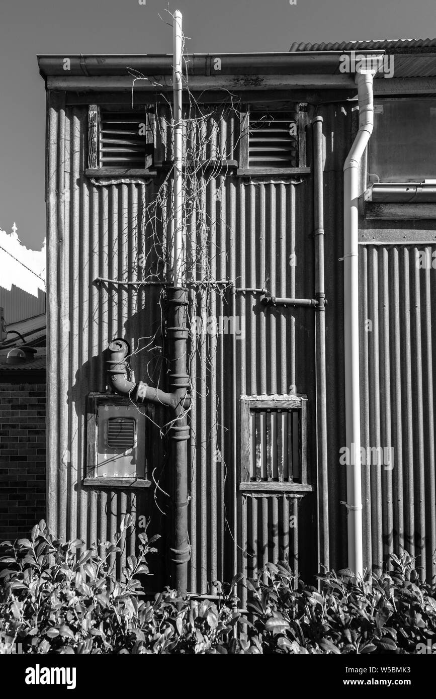 External plumbing at the rear of a corrugated iron building in Maitland New South Wales, Australia Stock Photo