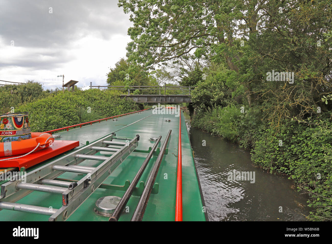 It's a tight fit getting a 68 foot (21 meter) long canal boat under bridges, Basingstoke Canal, UK. Stock Photo