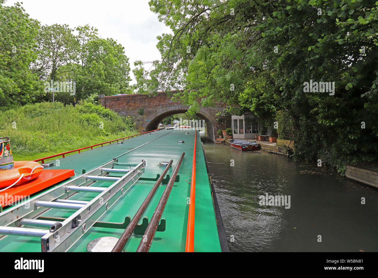 It's a tight fit getting a 68 foot (21 meter) long canal boat under bridges, Basingstoke Canal, UK. Stock Photo