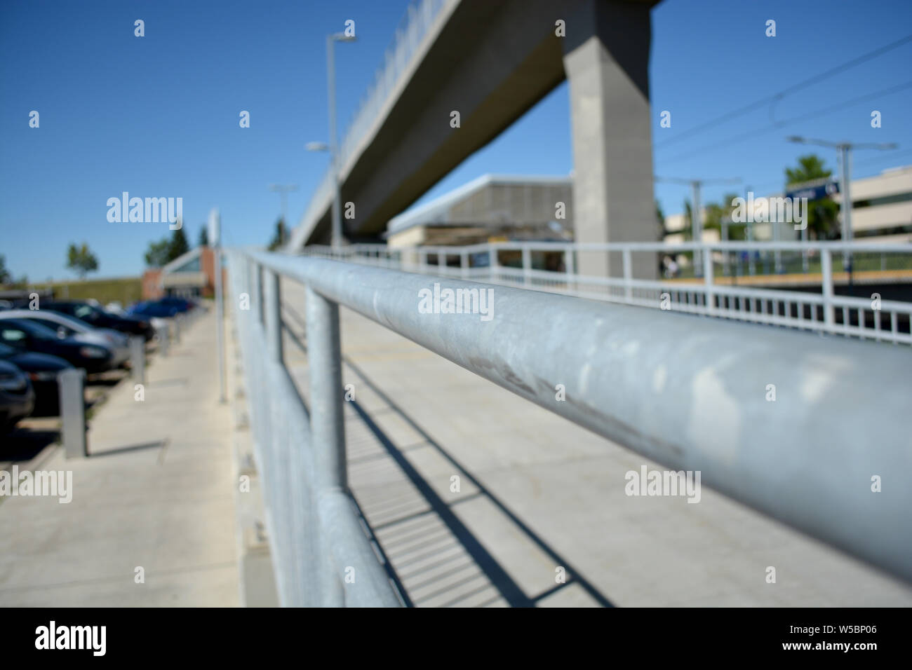 Pedestrian walkway by train track line at city station. Stock Photo