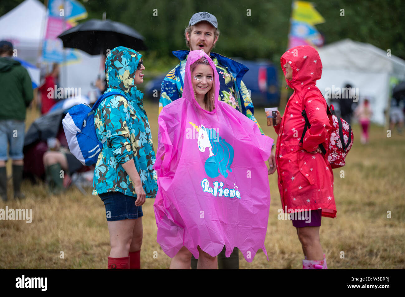 Standon, UK. Saturday 27 July 2019.  A group of friends not letting the wether dampen there spirits at Standon Calling set in the picturesque grounds of Standon Lordship © Jason Richardson / Alamy Live News Stock Photo