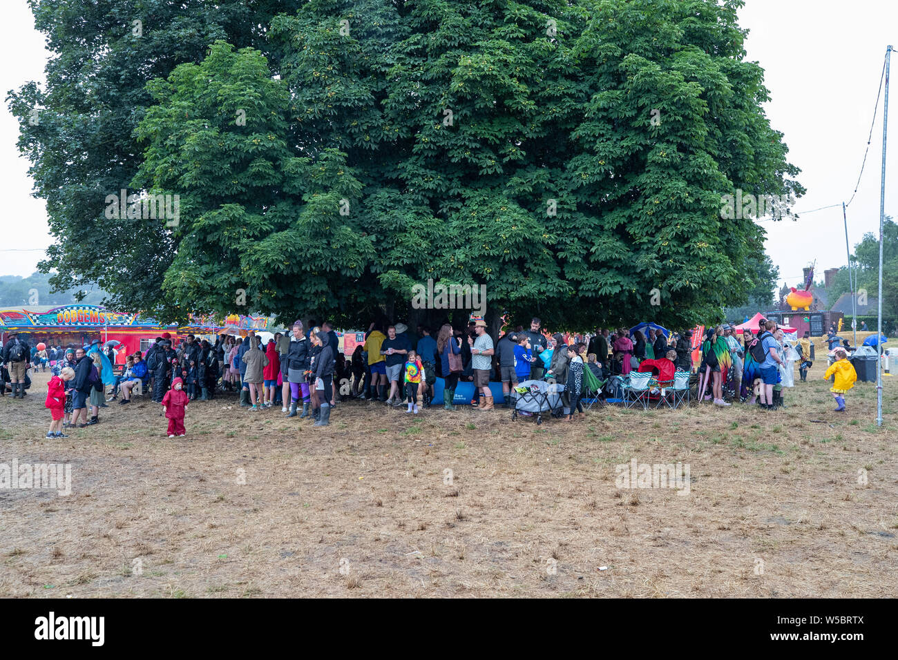 Standon, UK. Saturday 27 July 2019.  festival attendees take shelter from the rain at Standon Calling set in the picturesque grounds of Standon Lordship © Jason Richardson / Alamy Live News Stock Photo