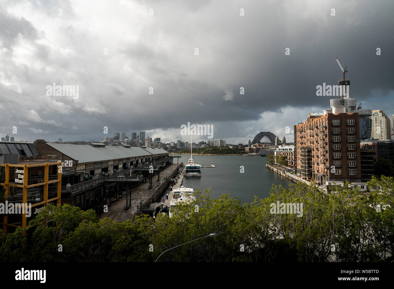 Pyrmont, New South Wales - JUNE 24th, 2019: Ominous clouds hang over Jones Bay Wharf with North Sydney visible in the background. Stock Photo