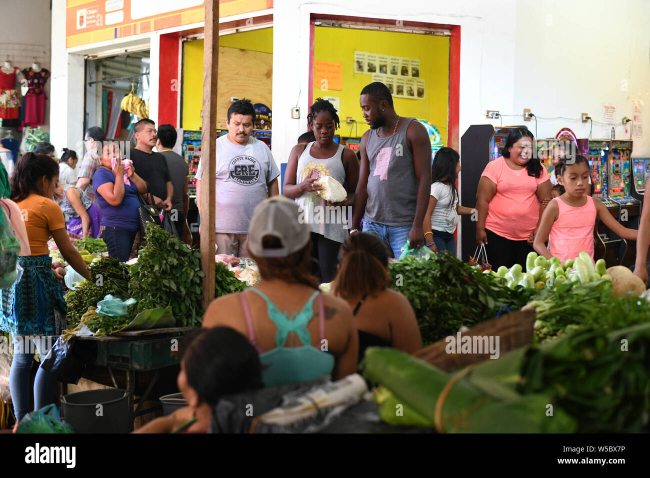 Chiapas, Mexico. 27th July, 2019. The new global melting pot: a Hatian couple bargains for a piece of cabbage in main market in downtown Tapachula. Mexico has witnessed an increase of migrants crossing the country to reach the US, and now hundreds wander the streets of this southern Mexican city, which is becoming one more new global melting pot. Credit: ZUMA Press, Inc./Alamy Live News Stock Photo