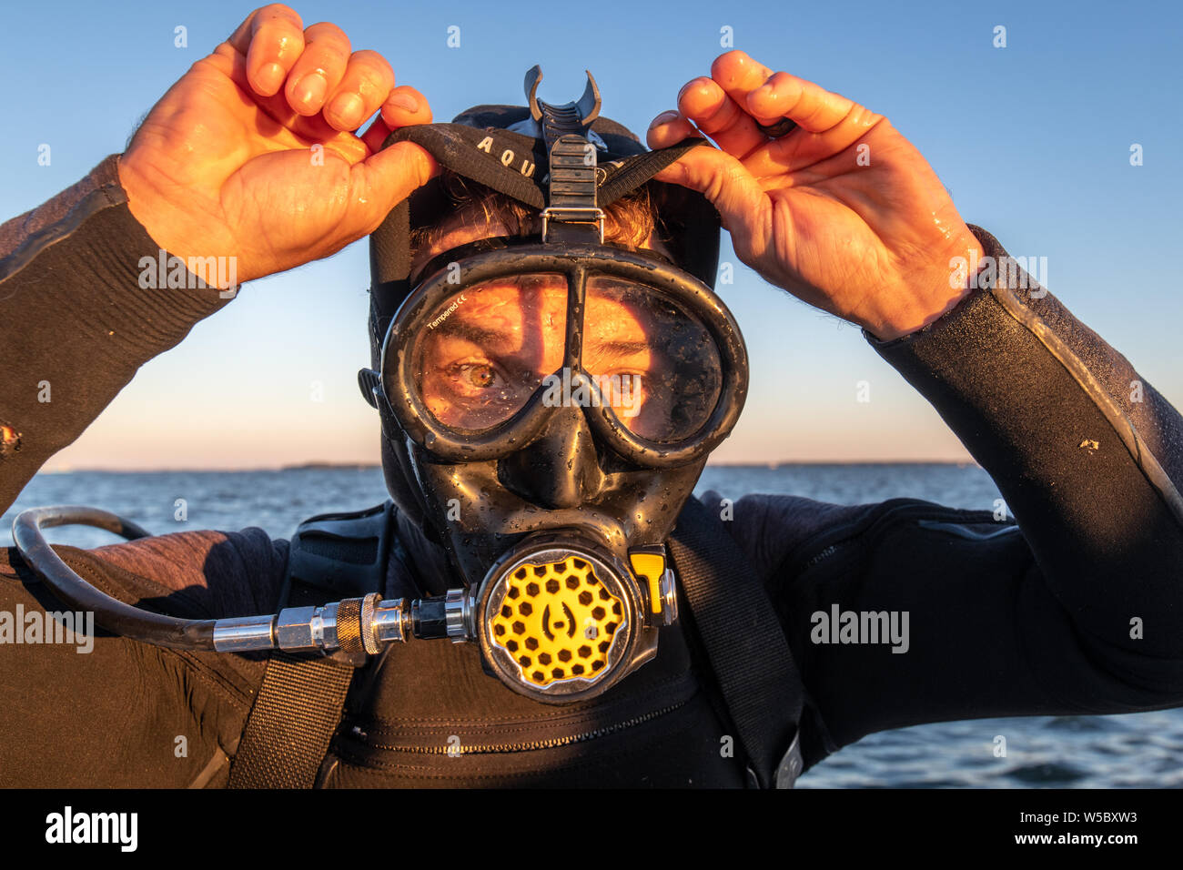 A wild oyster diver prepares and checks his gear before a dive, Wittman