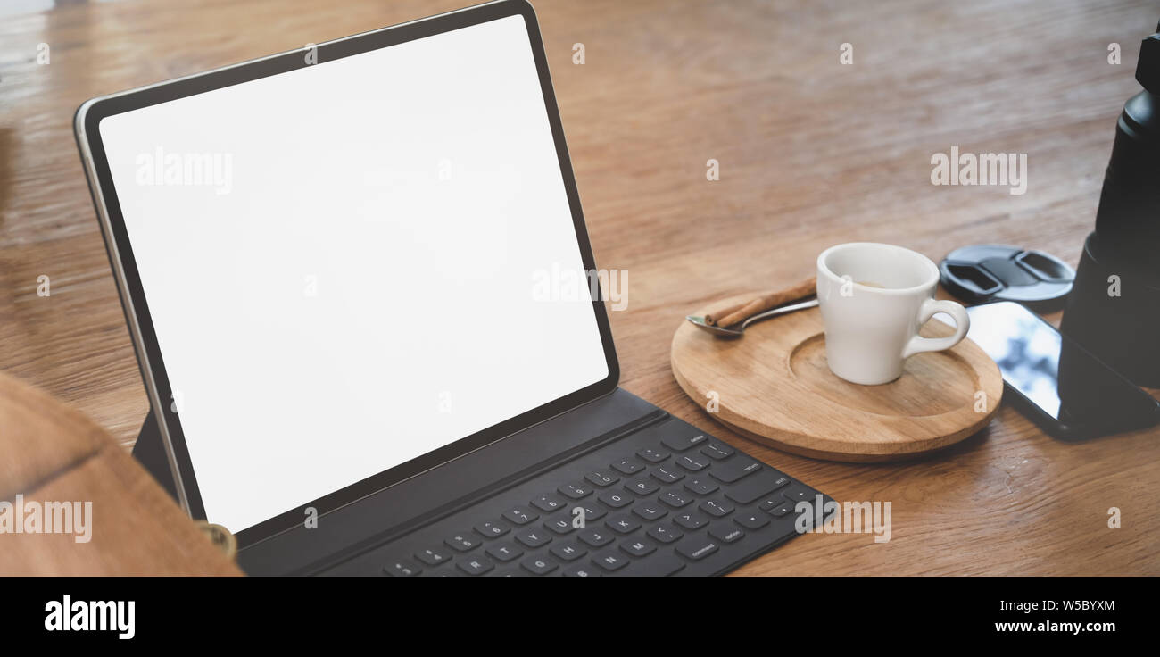 Open blank screen laptop in comfortable workplace with coffee cup and ...