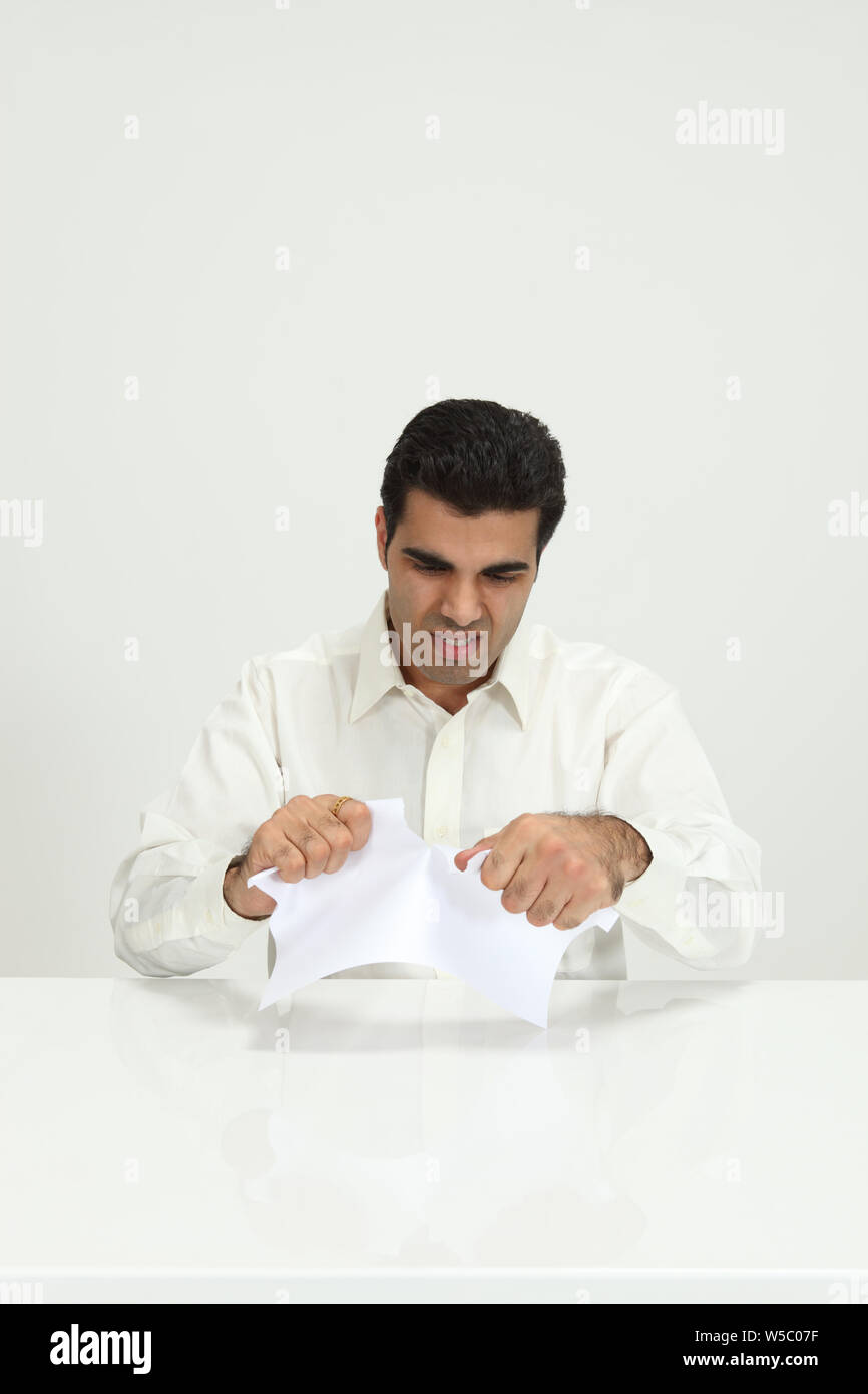 Businessman tearing paper Stock Photo