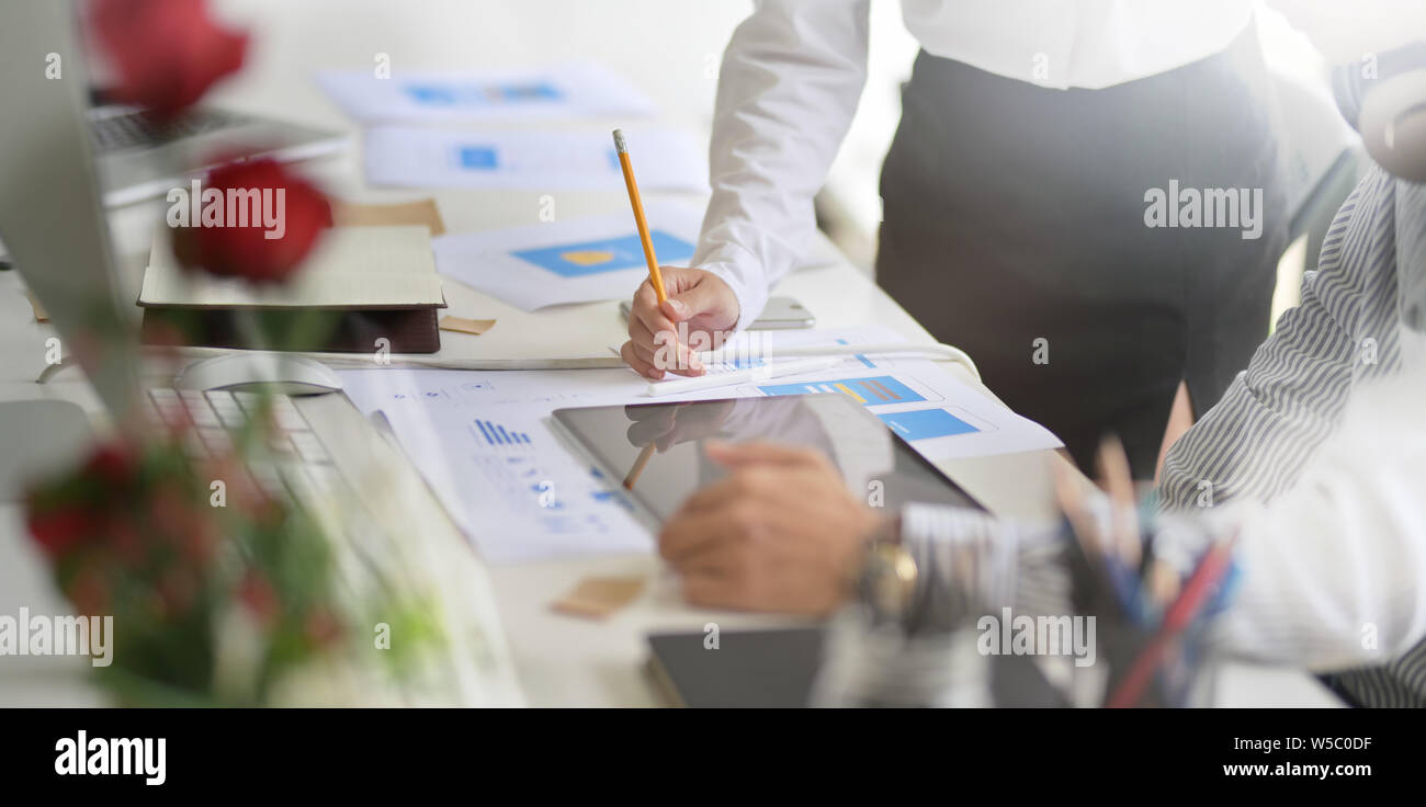 Young successful designers team brainstorming their upcoming project while working on tablet computer Stock Photo