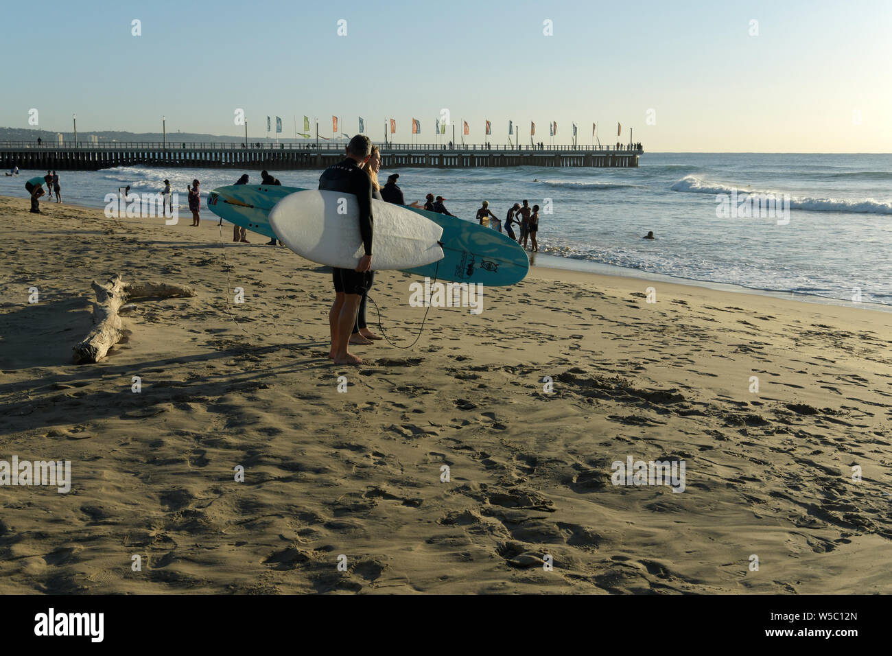 Durban, KwaZulu-Natal, South Africa, man and woman with surf boards standing on beach, surfers, surfing, landscape, lifestyle, candid, sport Stock Photo