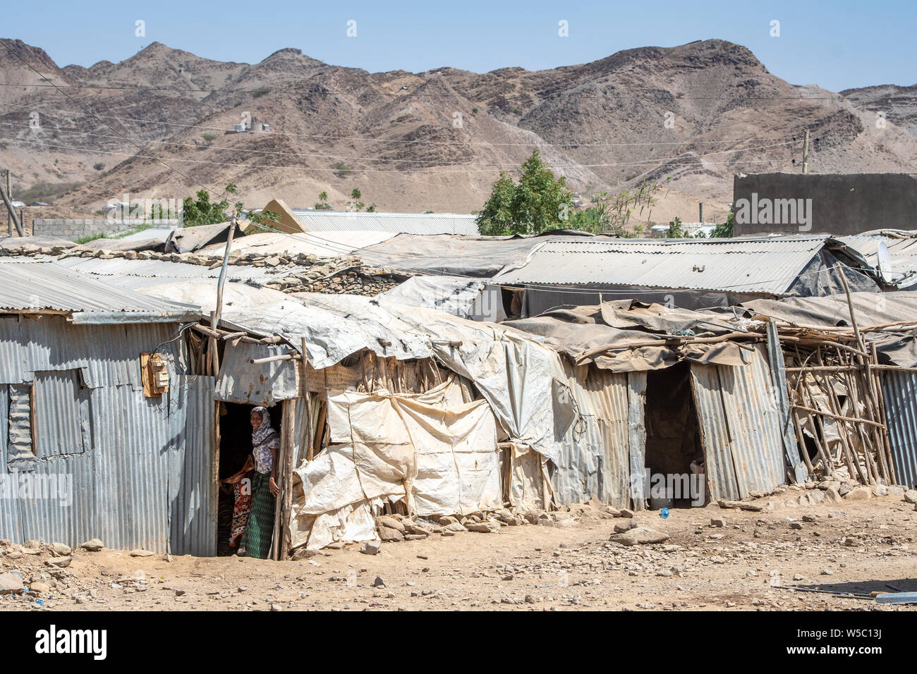 A woman entering a temporary shelter within the refugee camps of the Danakil Depression, Ethiopia. Danakil Depression ,  Ethiopia Stock Photo