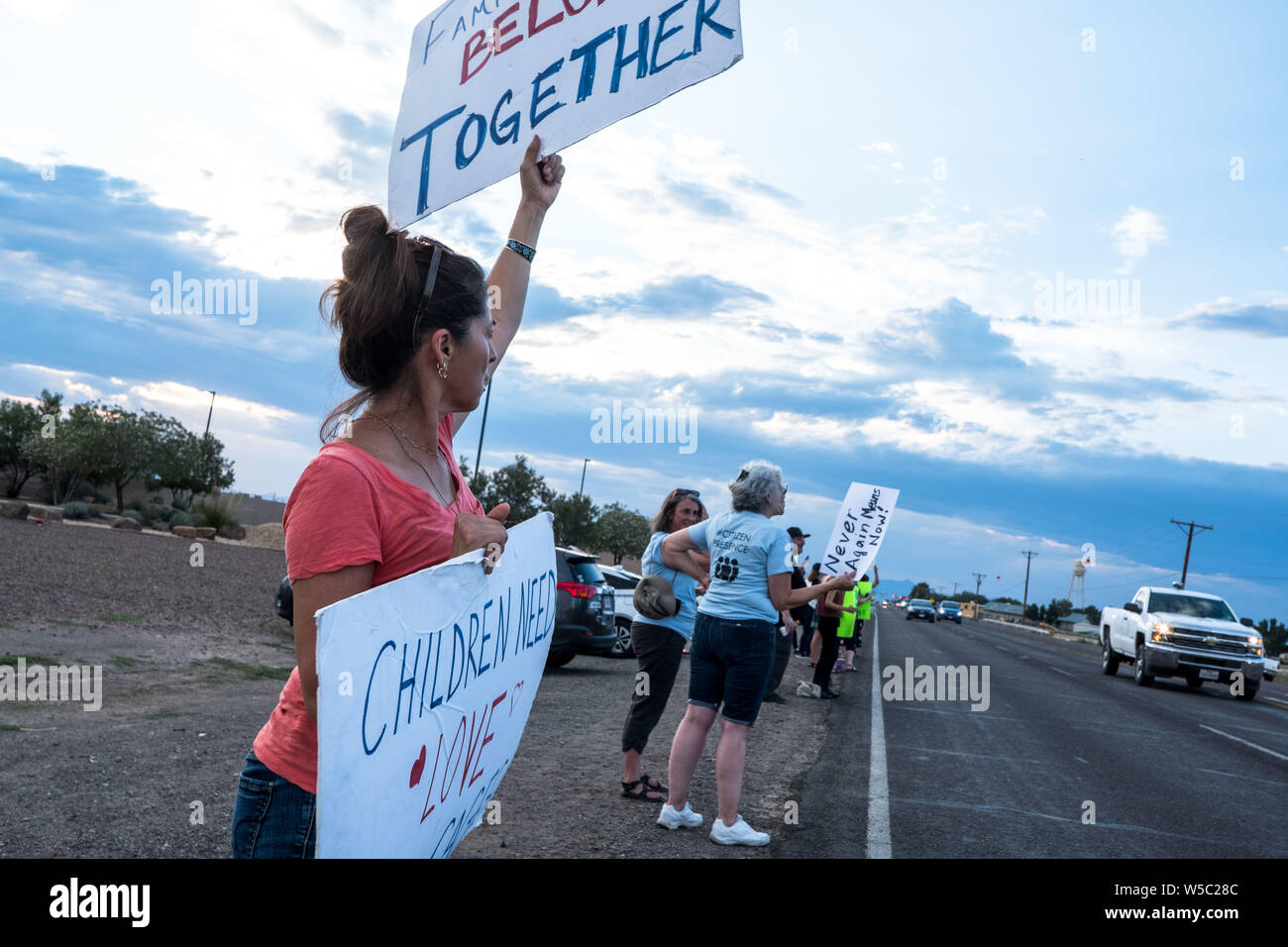 Texas, USA. 27th July, 2019. YVONNE NIVES of El Paso holds signs as she gathers with activists during a protest outside the U.S. Border Patrol station in Clint, Texas. The Border Patrol station has received criticism for previous reports of inadequate and poor conditions for migrants being held at the facility. Credit: ZUMA Press, Inc./Alamy Live News Stock Photo