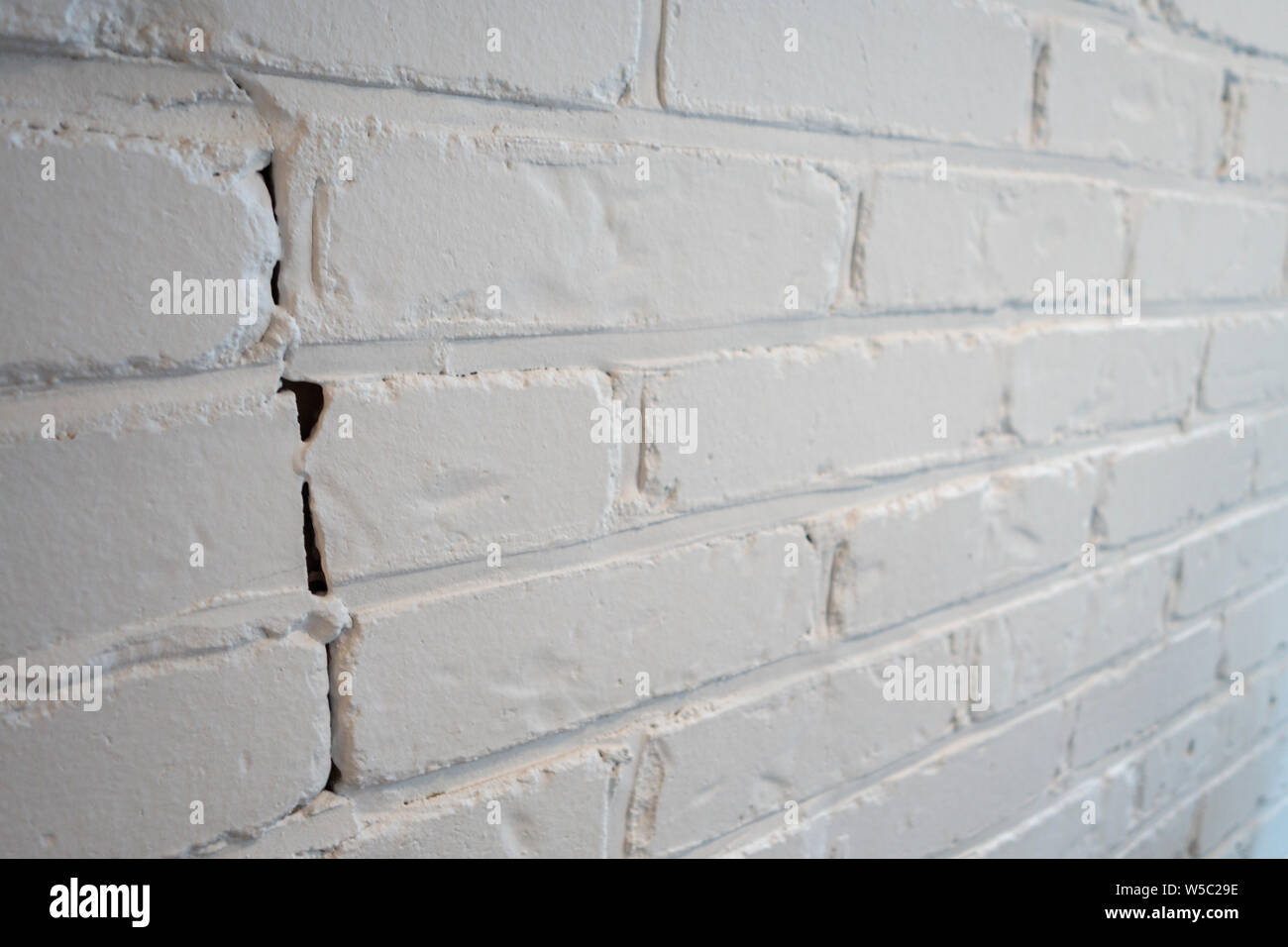 White Painted Brick Wall Background Indoors With A Crack