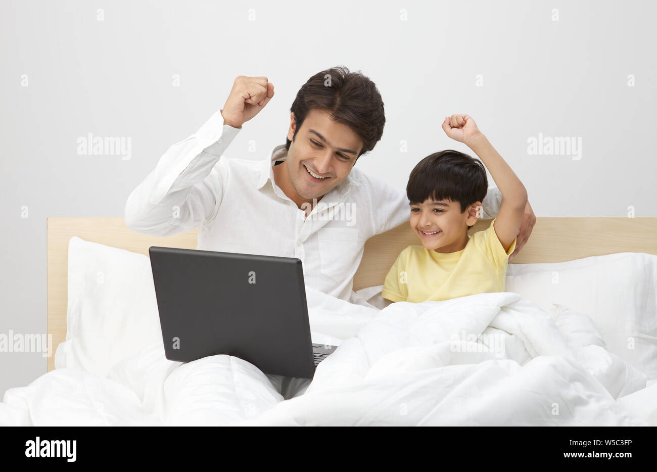 Man with his son working on a laptop Stock Photo