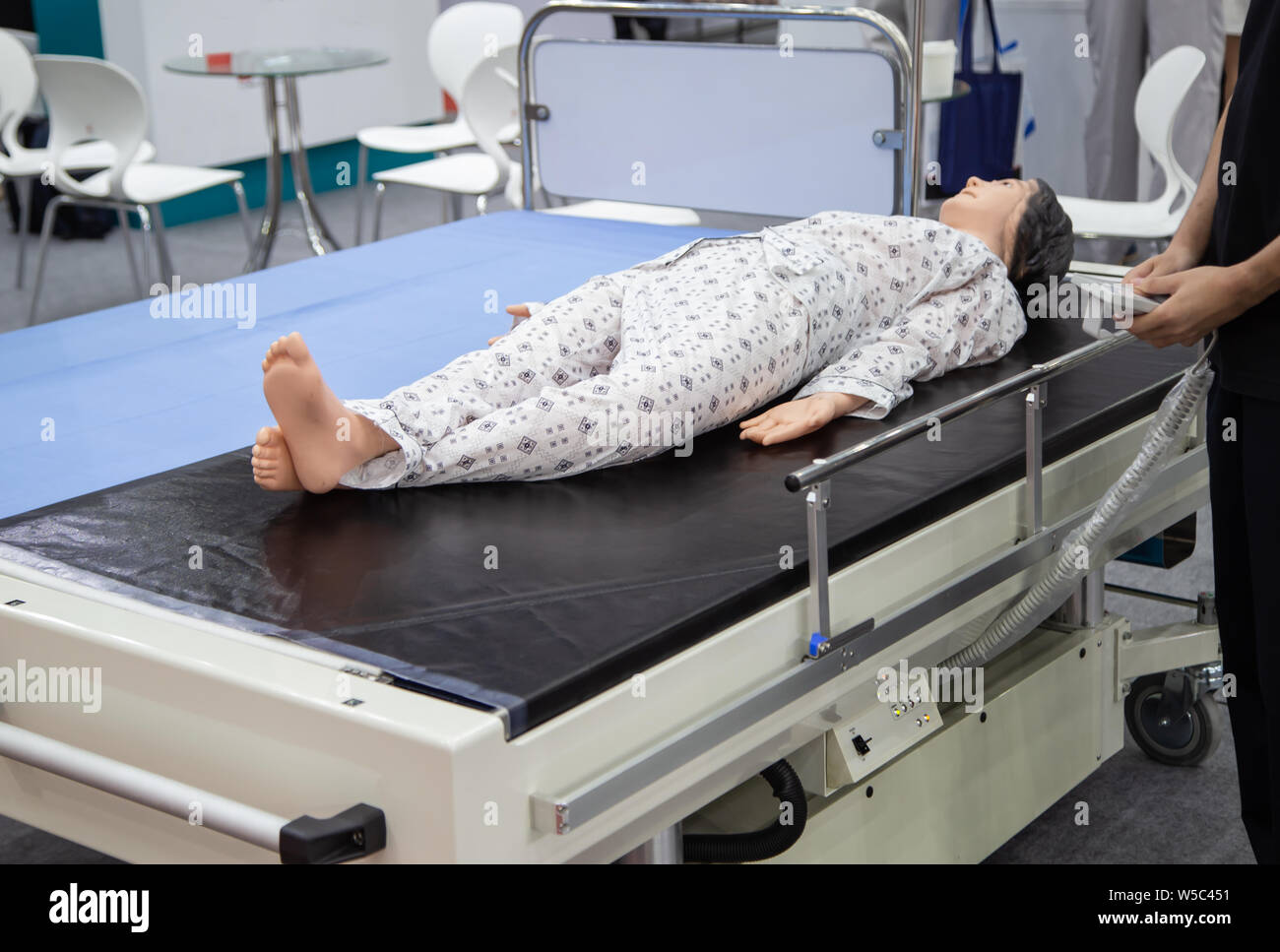 Patient dummy lying on mobile hospital bed while medic adjusting Stock ...