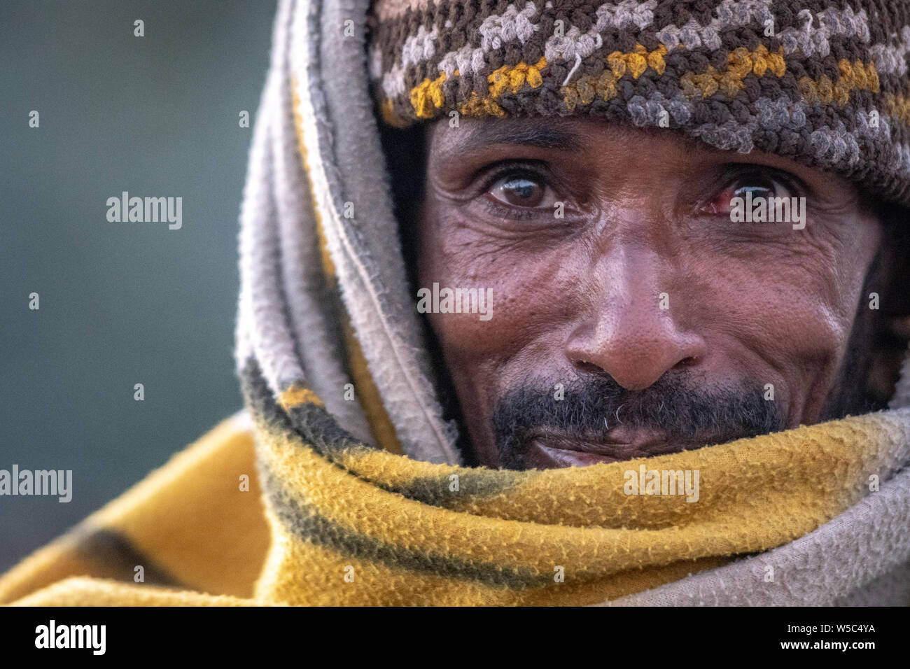 A young woman poses outside of her house for a photograph, Debre Berhan