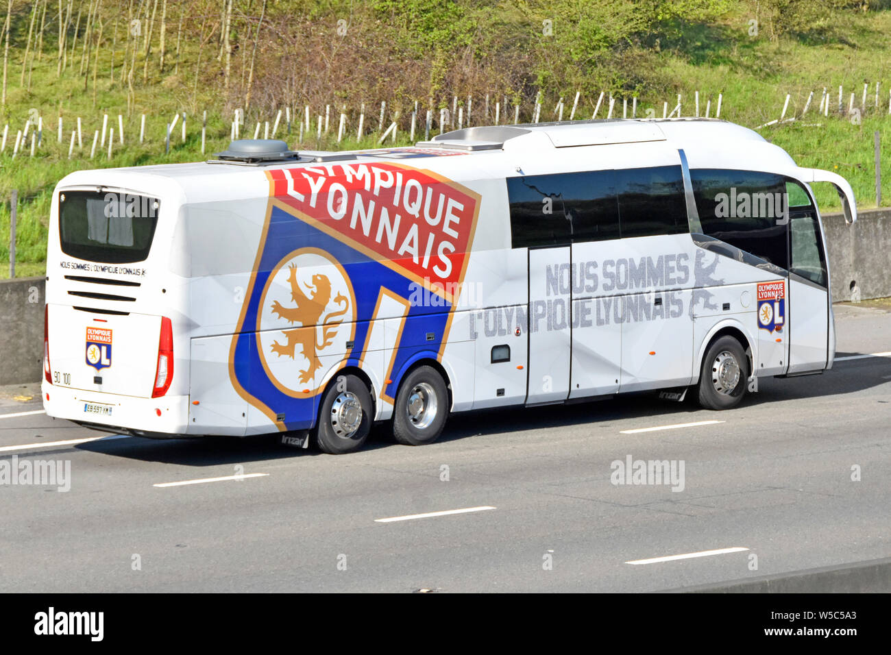Bus transport for Olympique Lyonnais French football club based in Lyon France with logo on team coach seen driving along M25 UK motorway England UK Stock Photo