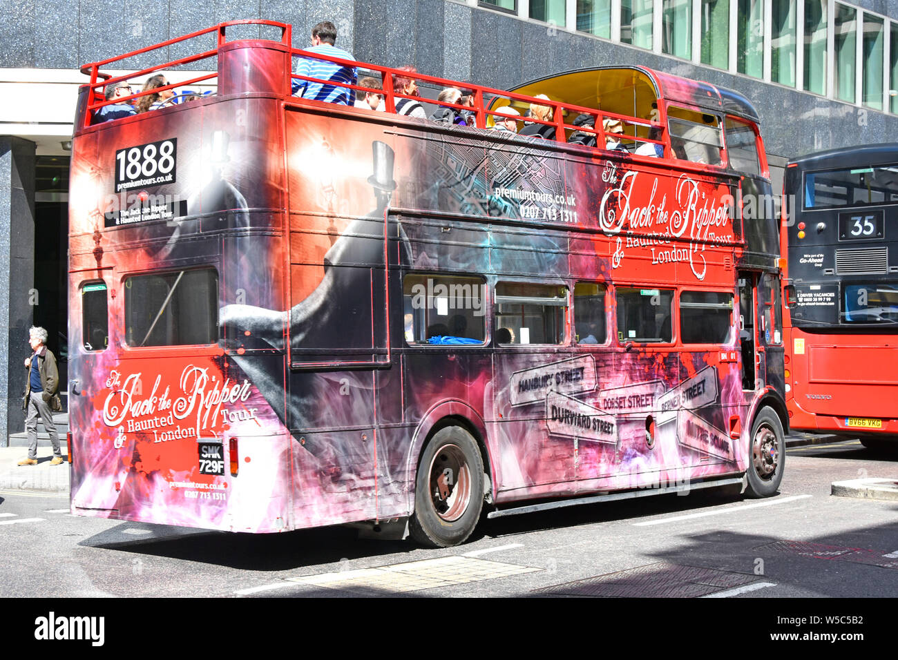 Historical Jack the Ripper open top double decker sightseeing tour bus  covered with suitable graphics top deck with tourists & guide England  London UK Stock Photo - Alamy