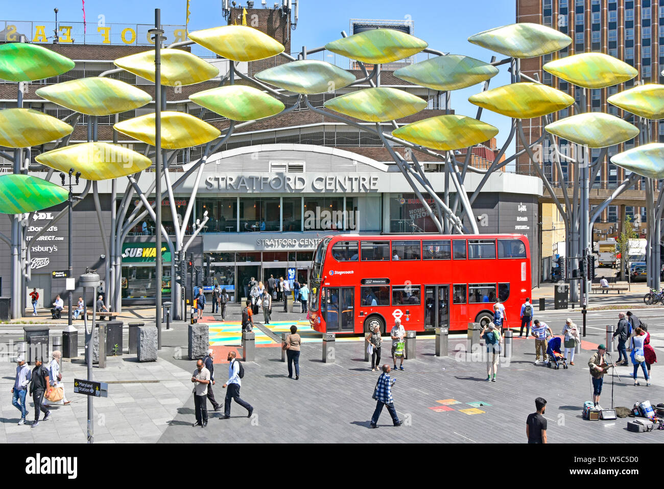 Red double decker Stagecoach public transport bus below Stratford Shoal titanium fish sculpture outside old shopping centre Newham London England UK Stock Photo