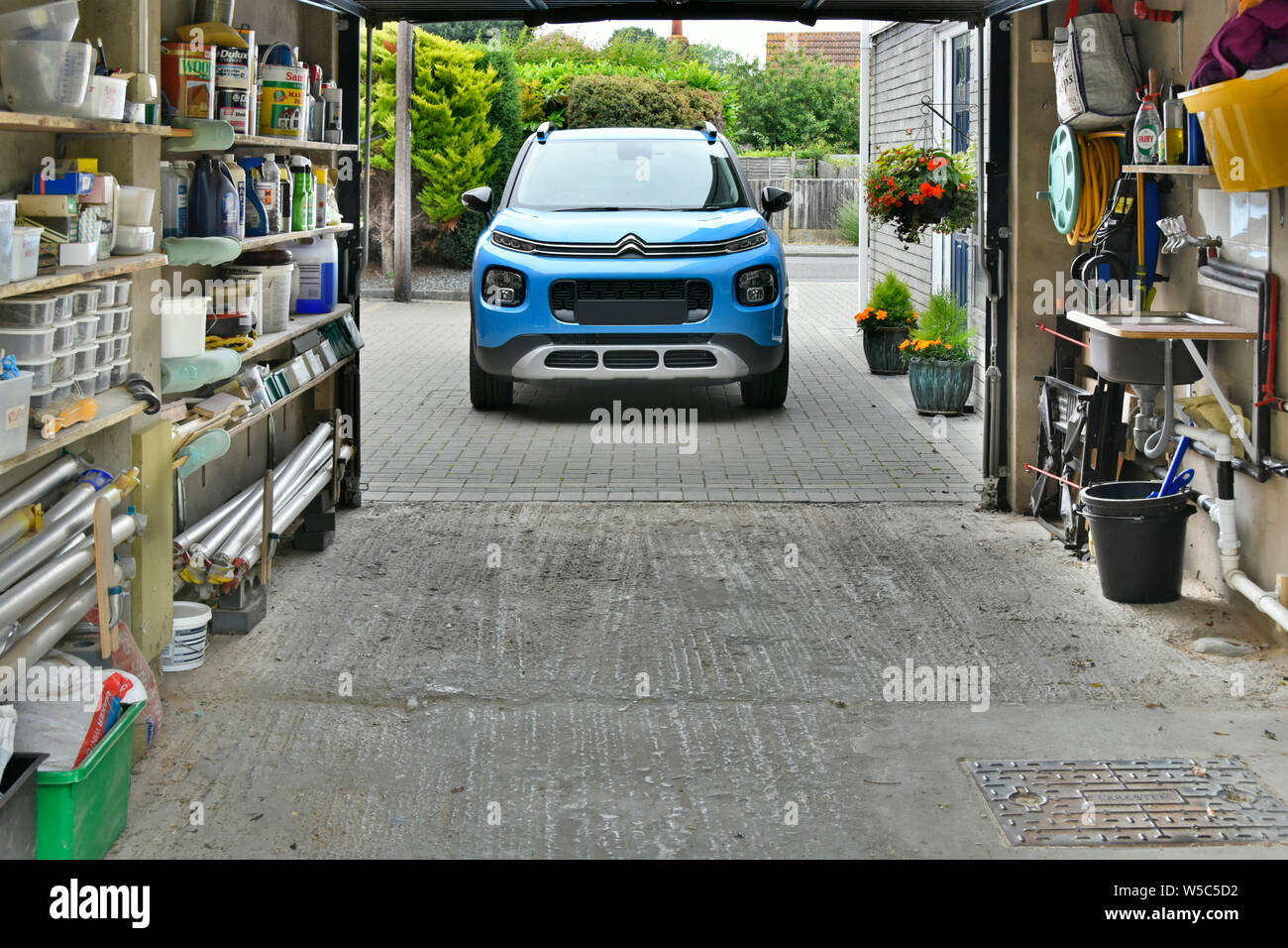 Citroen Aircross C3 SUV & driveway garage attached to house used for car & household storage of home paraphernalia tools & garden chemicals England UK Stock Photo