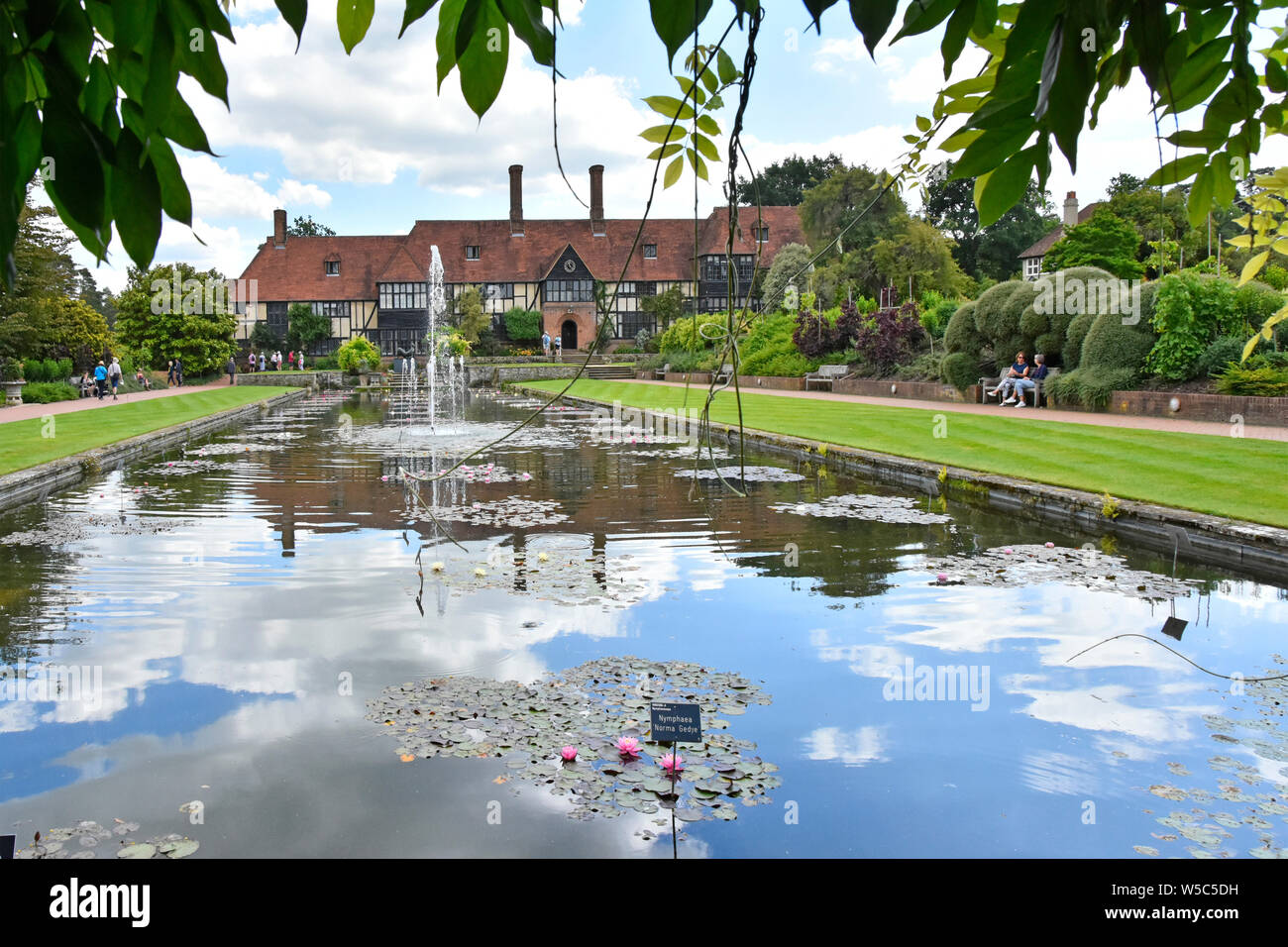 RHS Wisley garden & The Manor House laboratory building lawn fountain water feature in canal from water lily pavilion view platform Surrey England UK Stock Photo