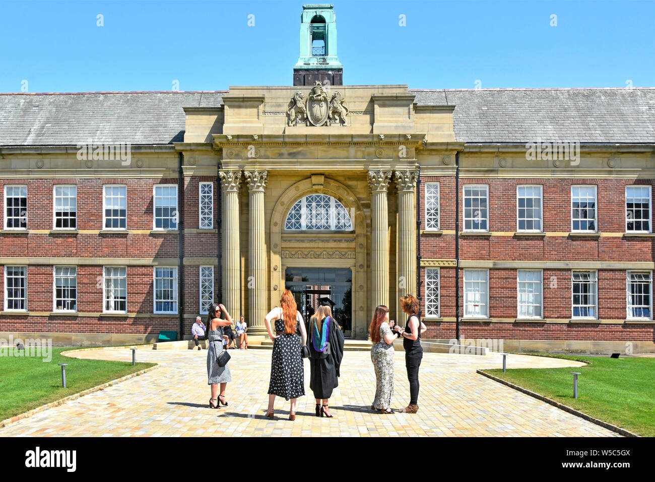 Family & friends Edge Hill University campus entrance on graduation day events confirming student education & degrees Ormskirk Lancashire England UK Stock Photo
