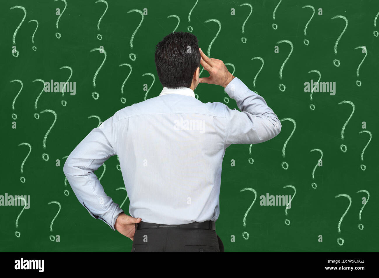 Businessman looking at question marks Stock Photo