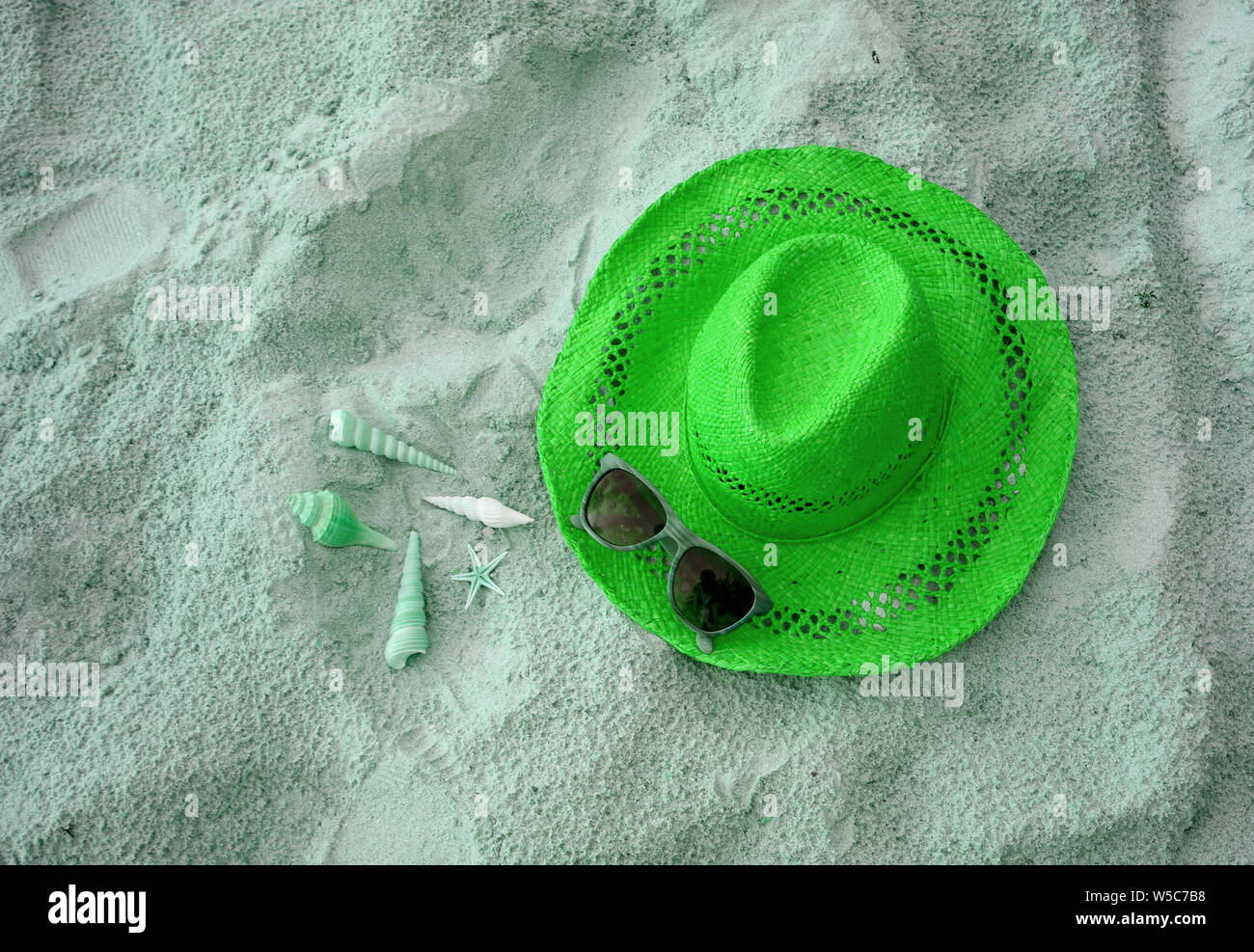 Straw hat with many types of little seashells and sunglasses on the ...