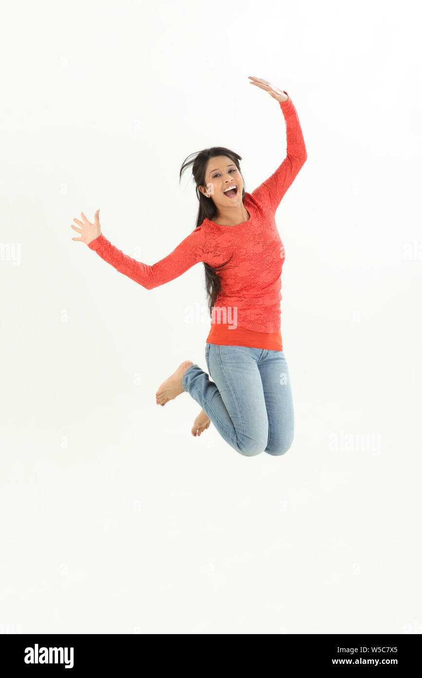 Woman jumping in air and smiling Stock Photo - Alamy