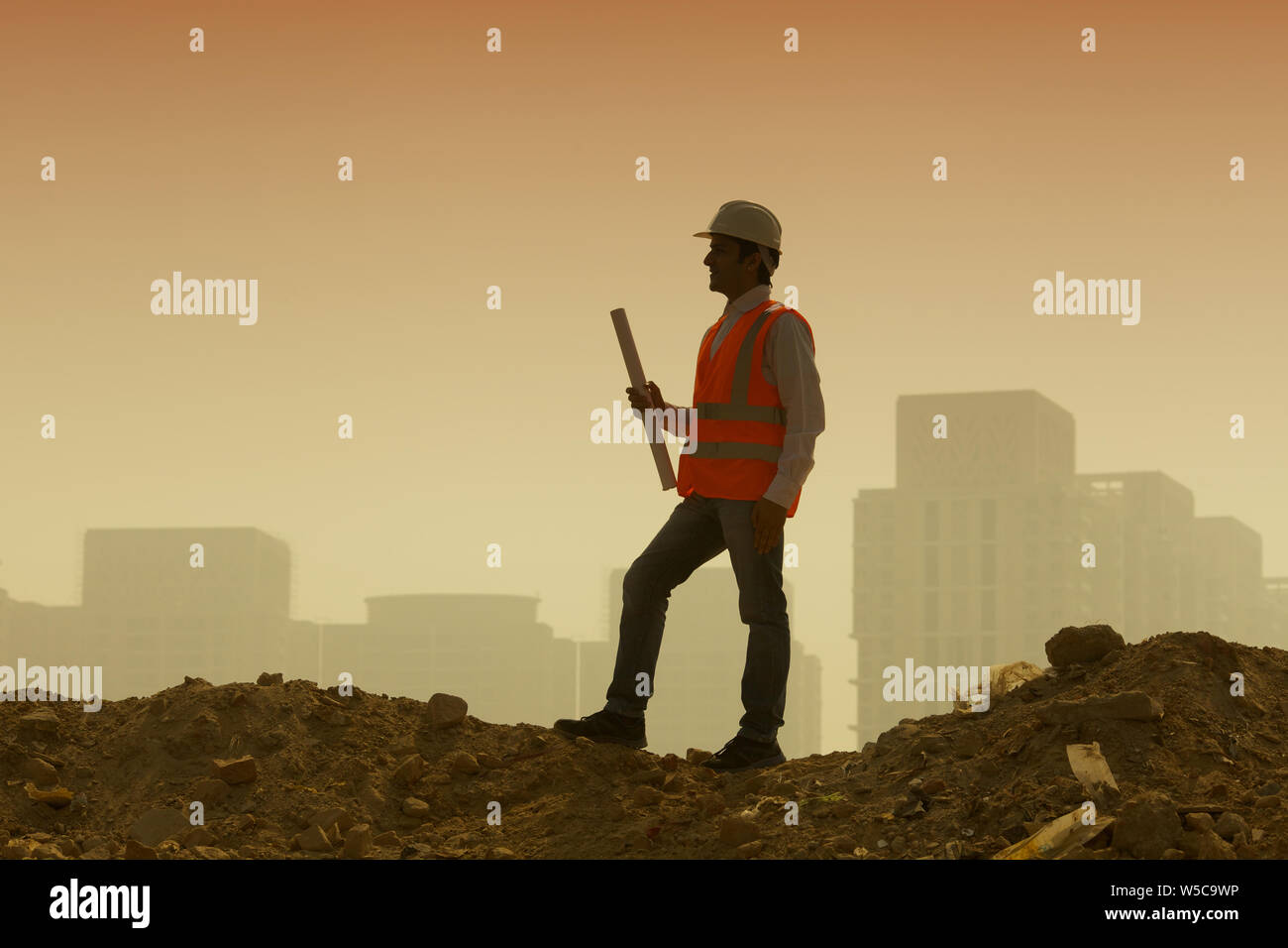 Architect holding blueprint at construction site Stock Photo - Alamy