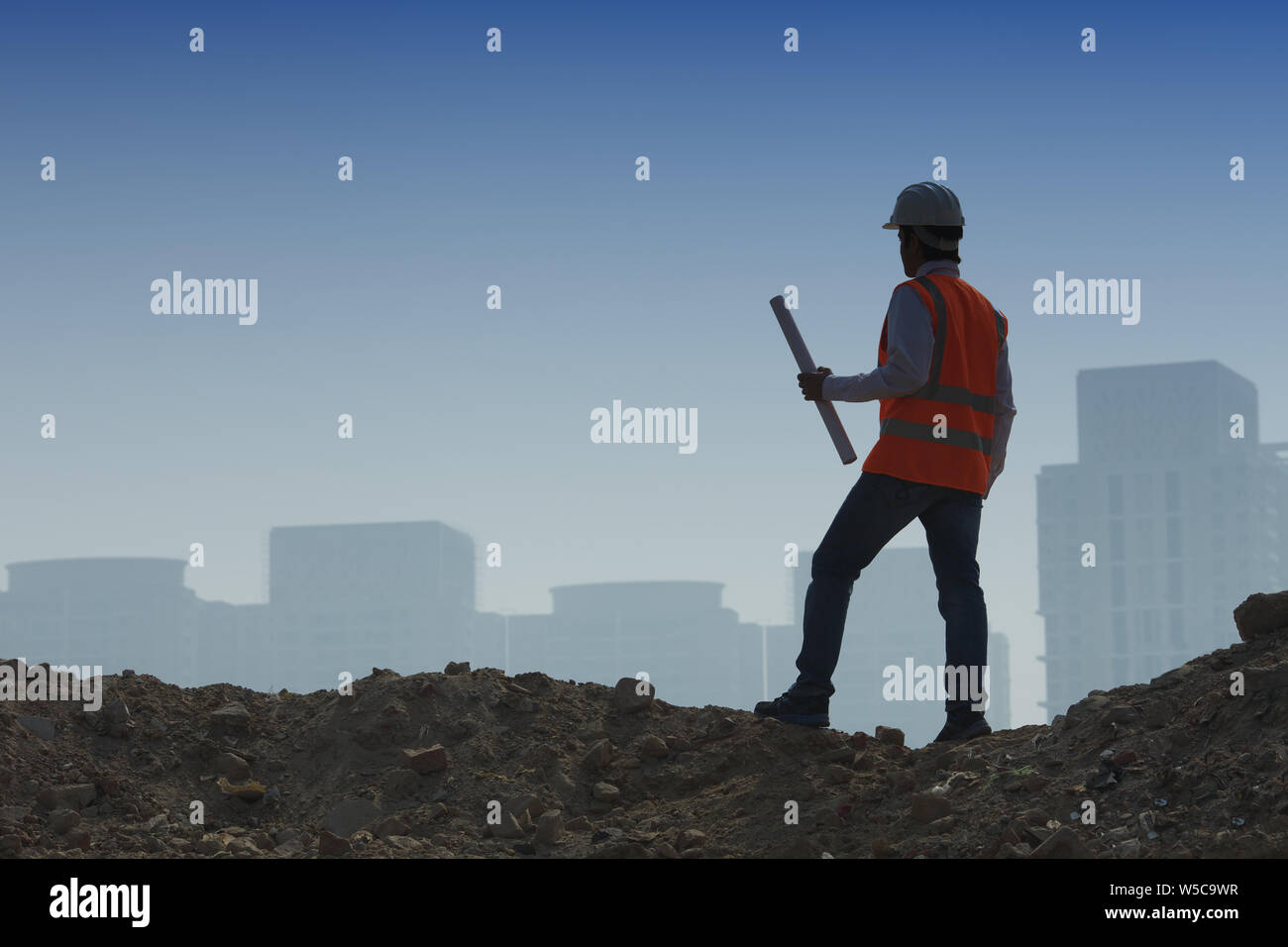 Architect holding blueprint at construction site Stock Photo - Alamy