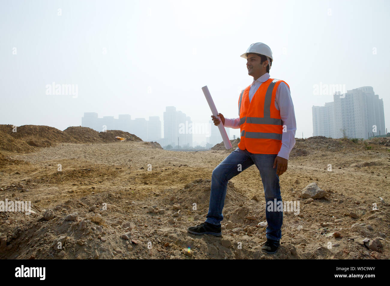 Architect holding blueprint at construction site Stock Photo - Alamy