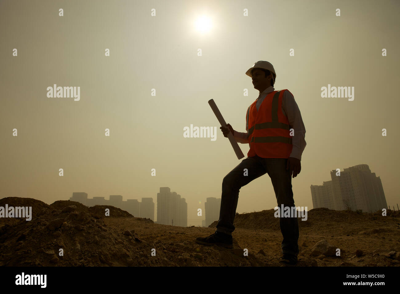 Architect holding blueprint at construction site Stock Photo - Alamy
