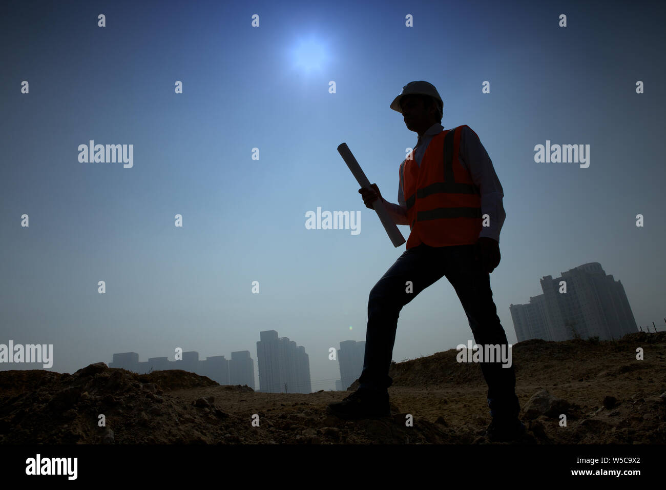 Architect holding blueprint at construction site Stock Photo - Alamy