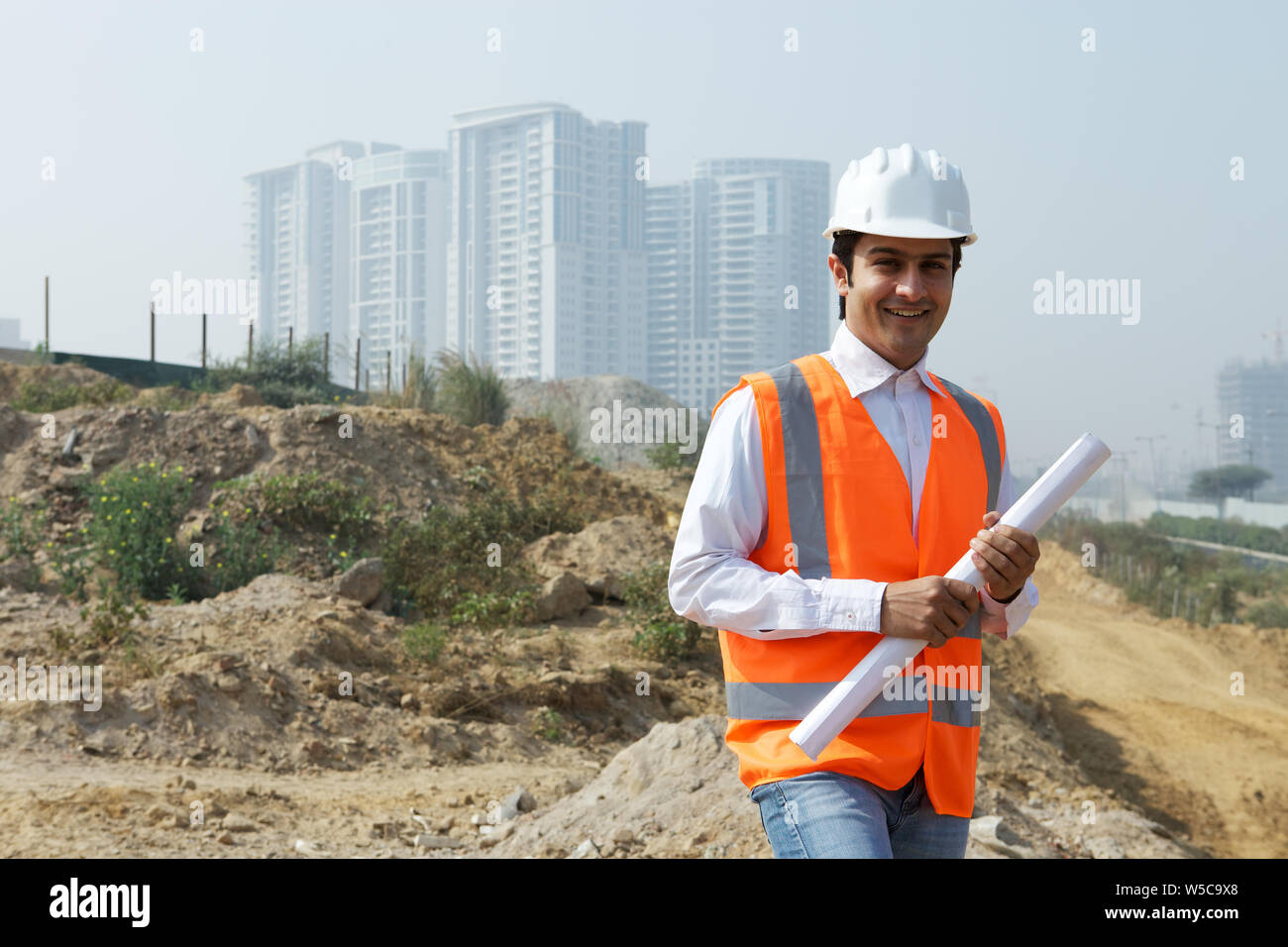 Architect holding blueprint at construction site Stock Photo - Alamy