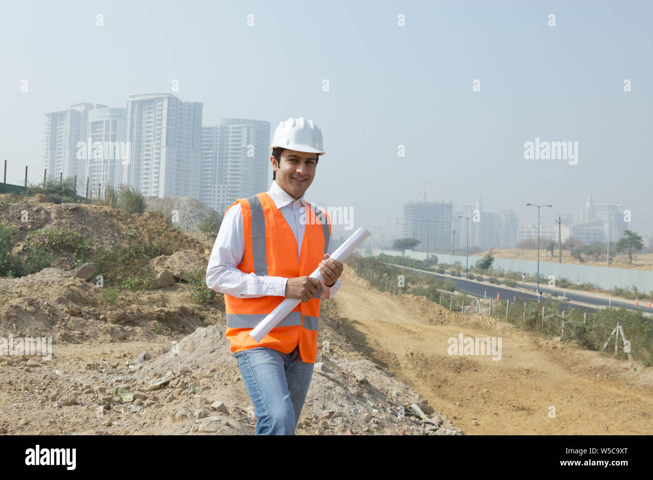 Architect holding blueprint at construction site Stock Photo - Alamy