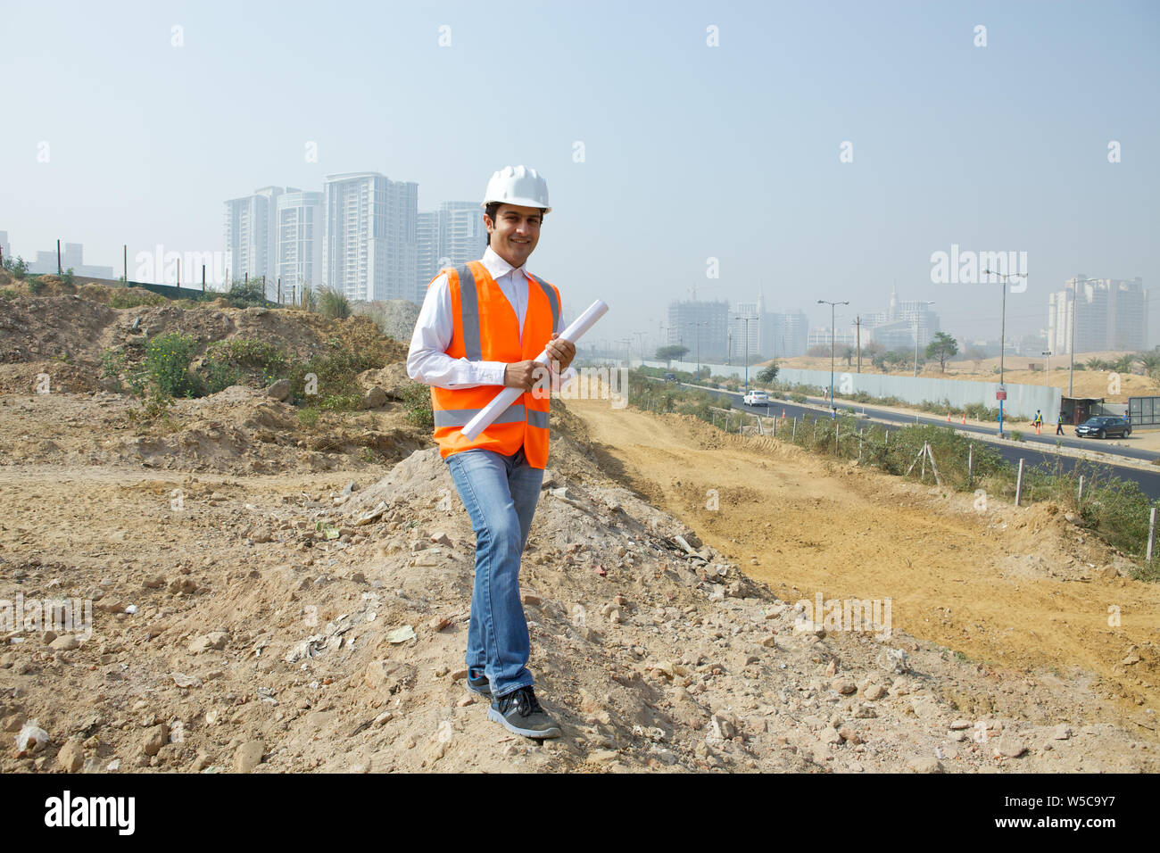 Architect holding blueprint at construction site Stock Photo - Alamy