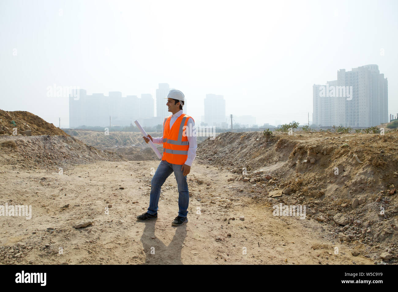 Architect holding blueprint at construction site Stock Photo - Alamy