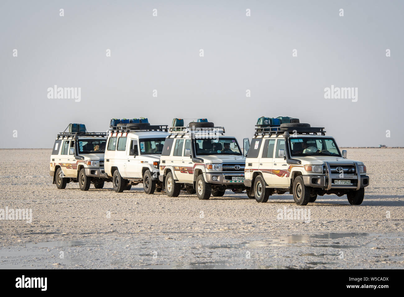 Land Cruisers drive through the salt flats in the Danakil Depression