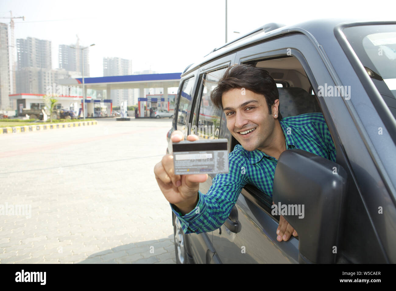 Man showing a credit card in a car Stock Photo