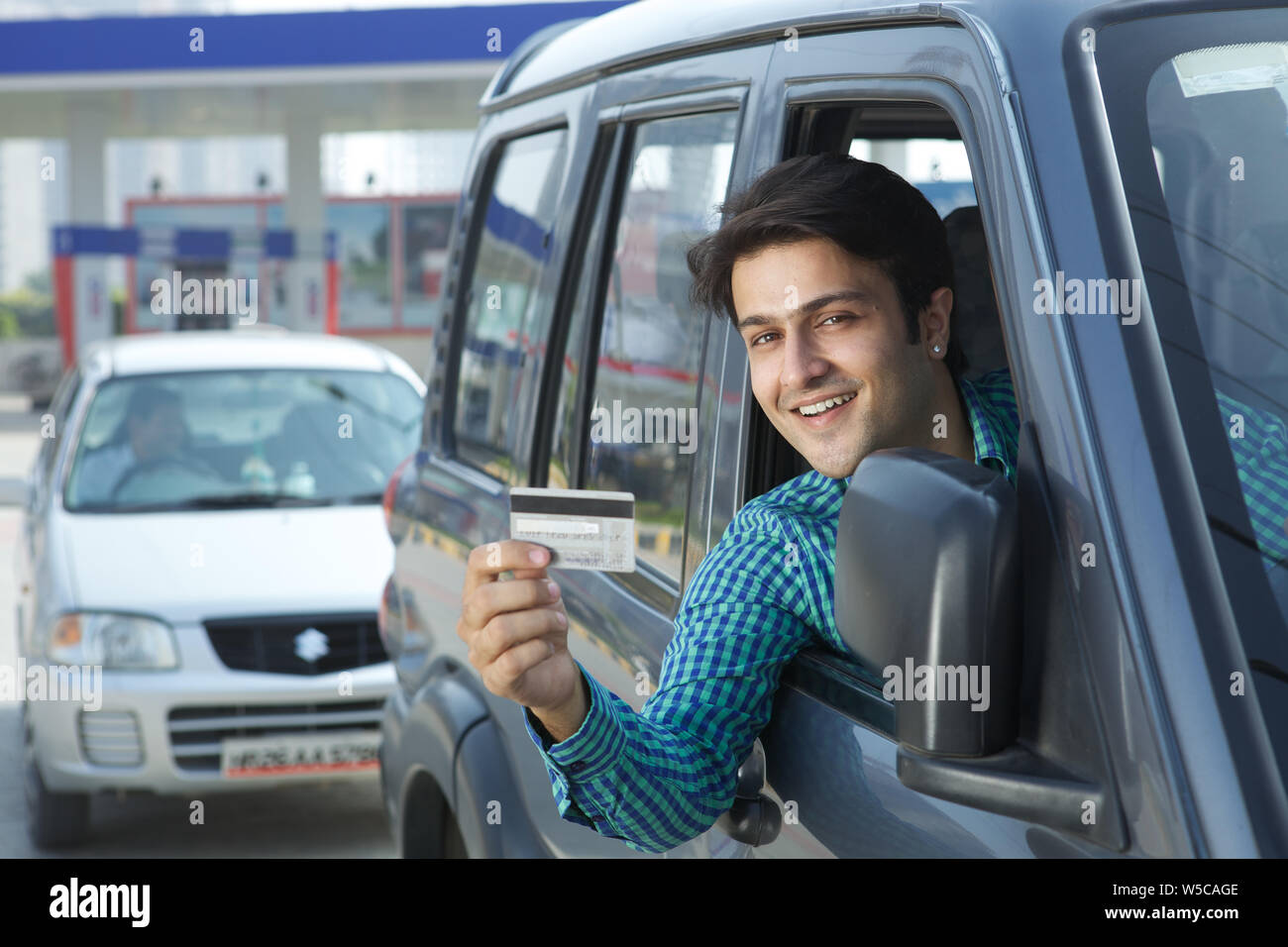 Man showing a credit card in a car Stock Photo