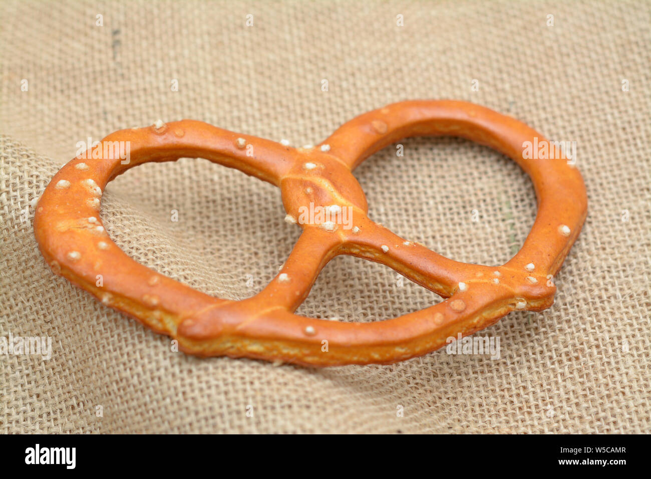 single crispy pretzel  on burlap on table Stock Photo