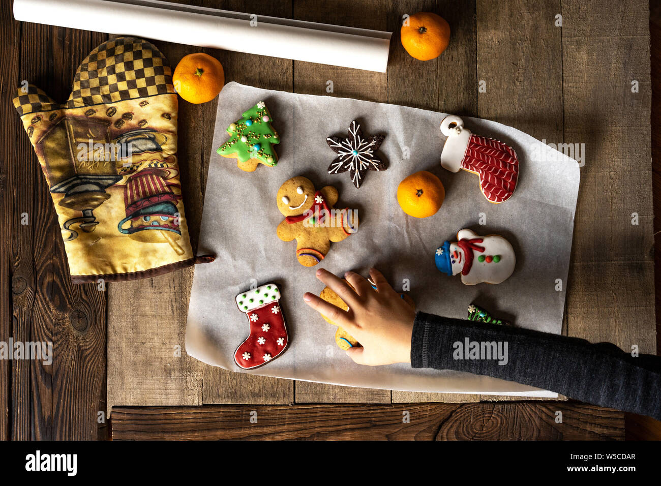 Children's hand sneaks festive Christmas glazed gingerbread Stock Photo