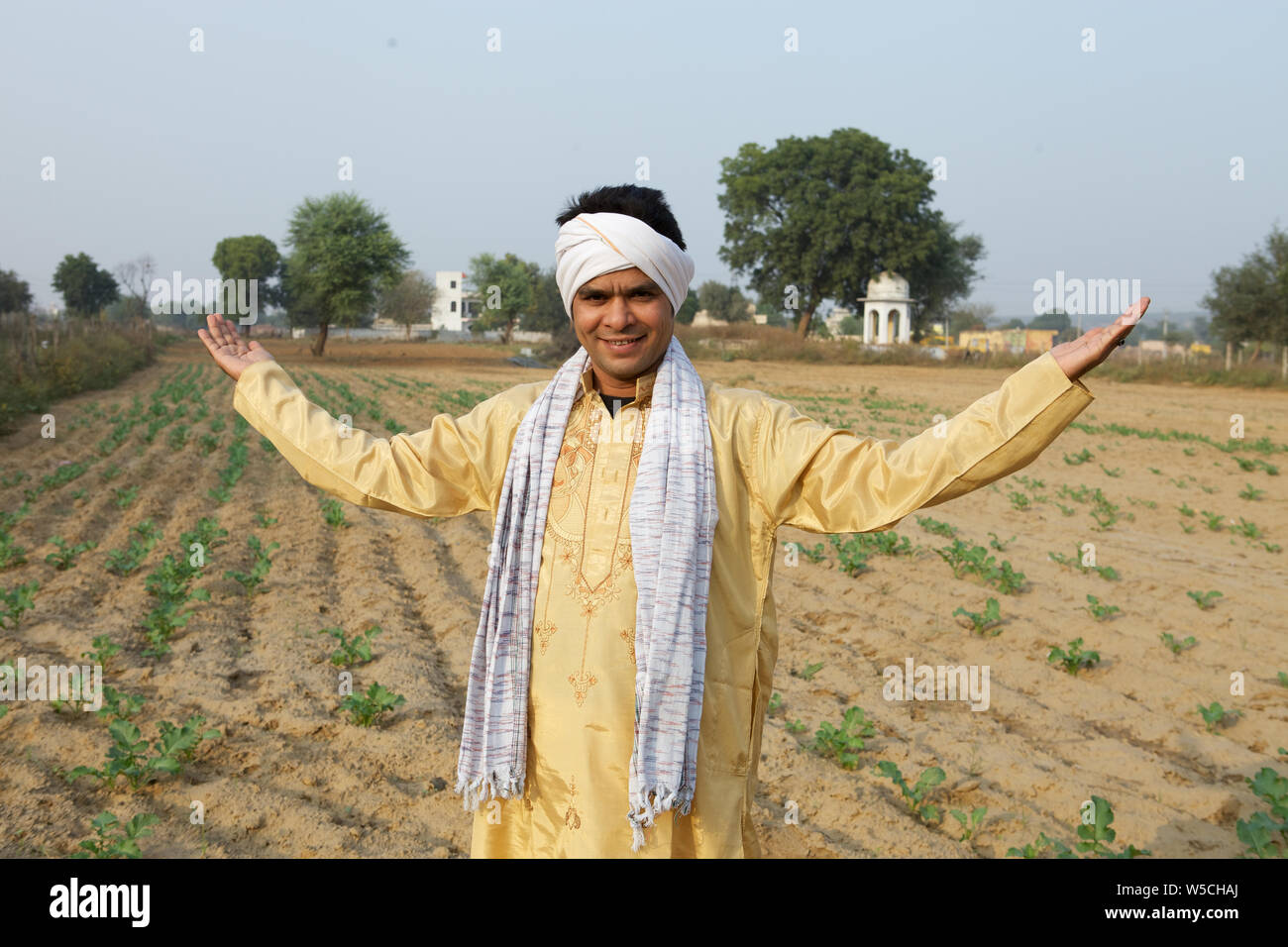 Farmer showing his field and smiling Stock Photo - Alamy