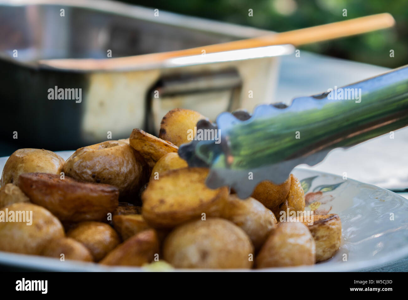 Baked golden potatoes delicious food on a white plate, ready to eat - Romanian food. Stock Photo