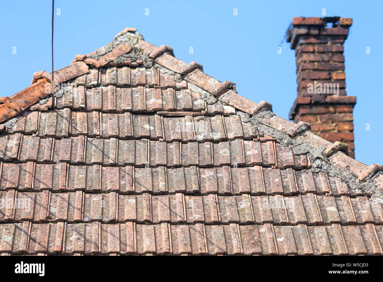 Details with the old ceramic roof tiles and with the red brick chimney ...