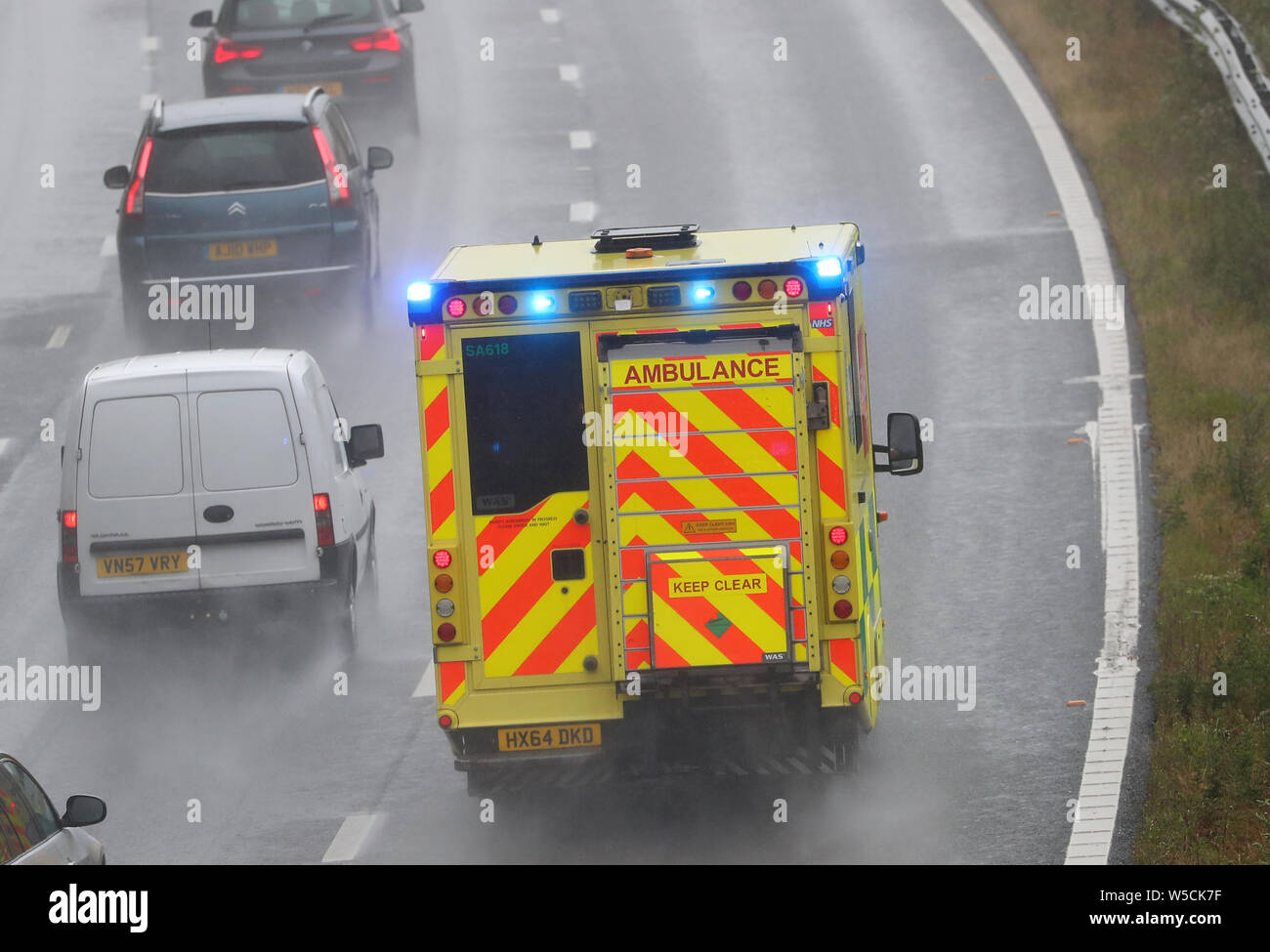 A South Central Ambulance with blue flashing lights on the M3 motorway Stock Photo